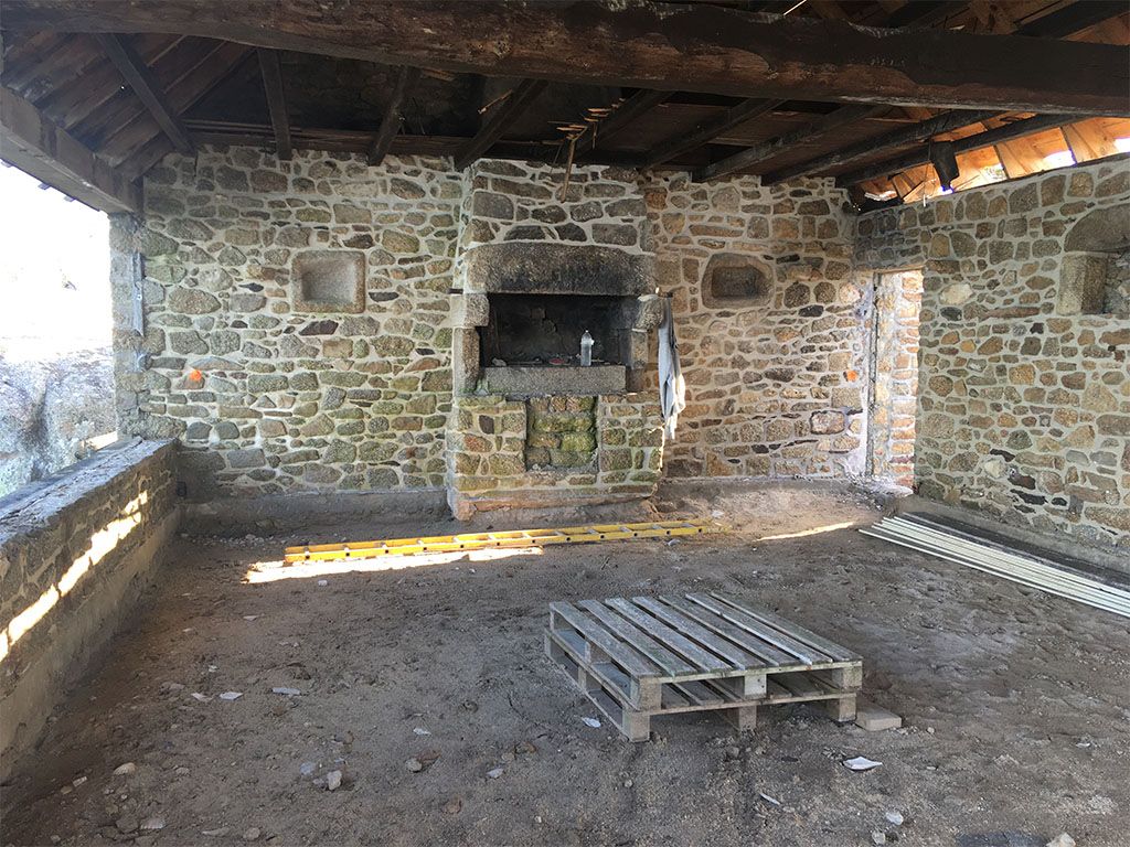 intérieur d'une maison en pierres avec cheminée